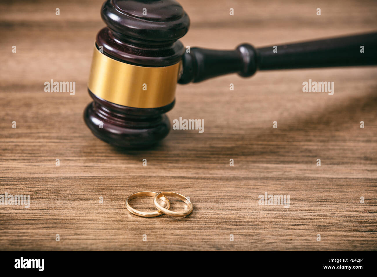 Scheidung Konzept. Trauringe und Richter Hammer auf hölzernen Hintergrund Kopie Raum Stockfoto
