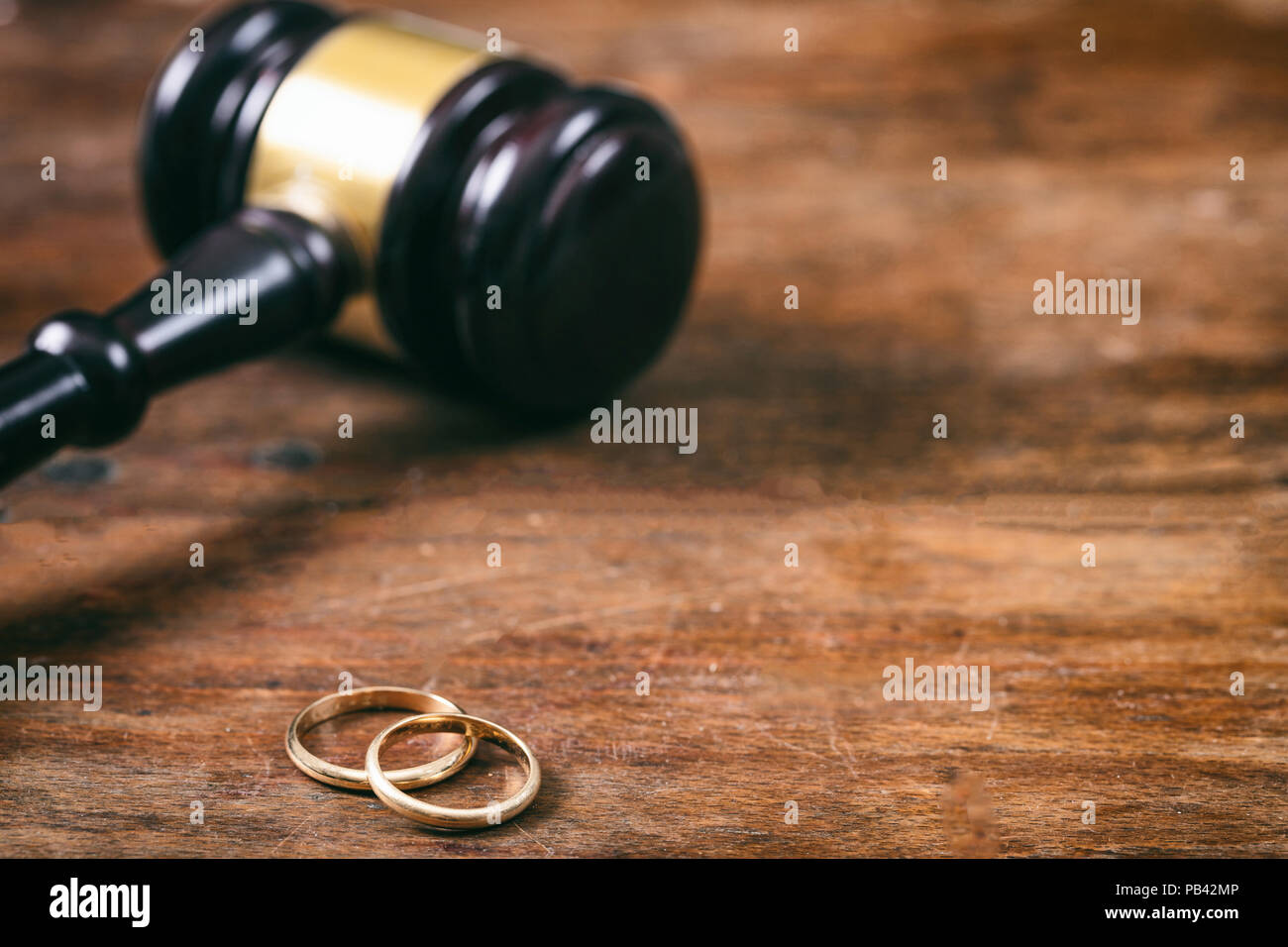 Scheidung Konzept. Trauringe und Richter Hammer auf hölzernen Hintergrund Kopie Raum Stockfoto