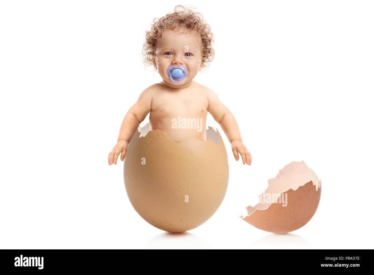 Baby Boy mit einem Schnuller aus eine Eierschale auf weißem Hintergrund Stockfoto