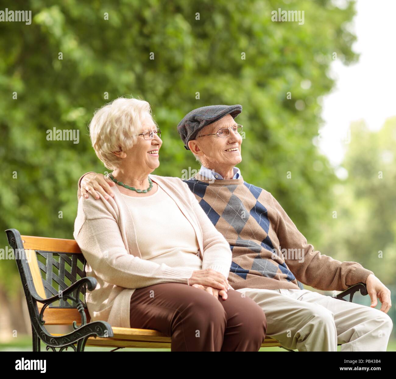 Senior Paar sitzen auf einer Bank im Freien Stockfoto