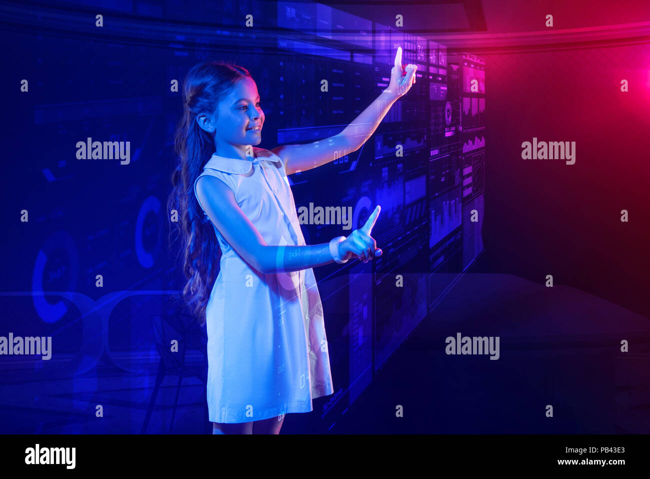 Neugierige Mädchen Gefühl zufrieden, während mit einem futuristischen Computer Stockfoto