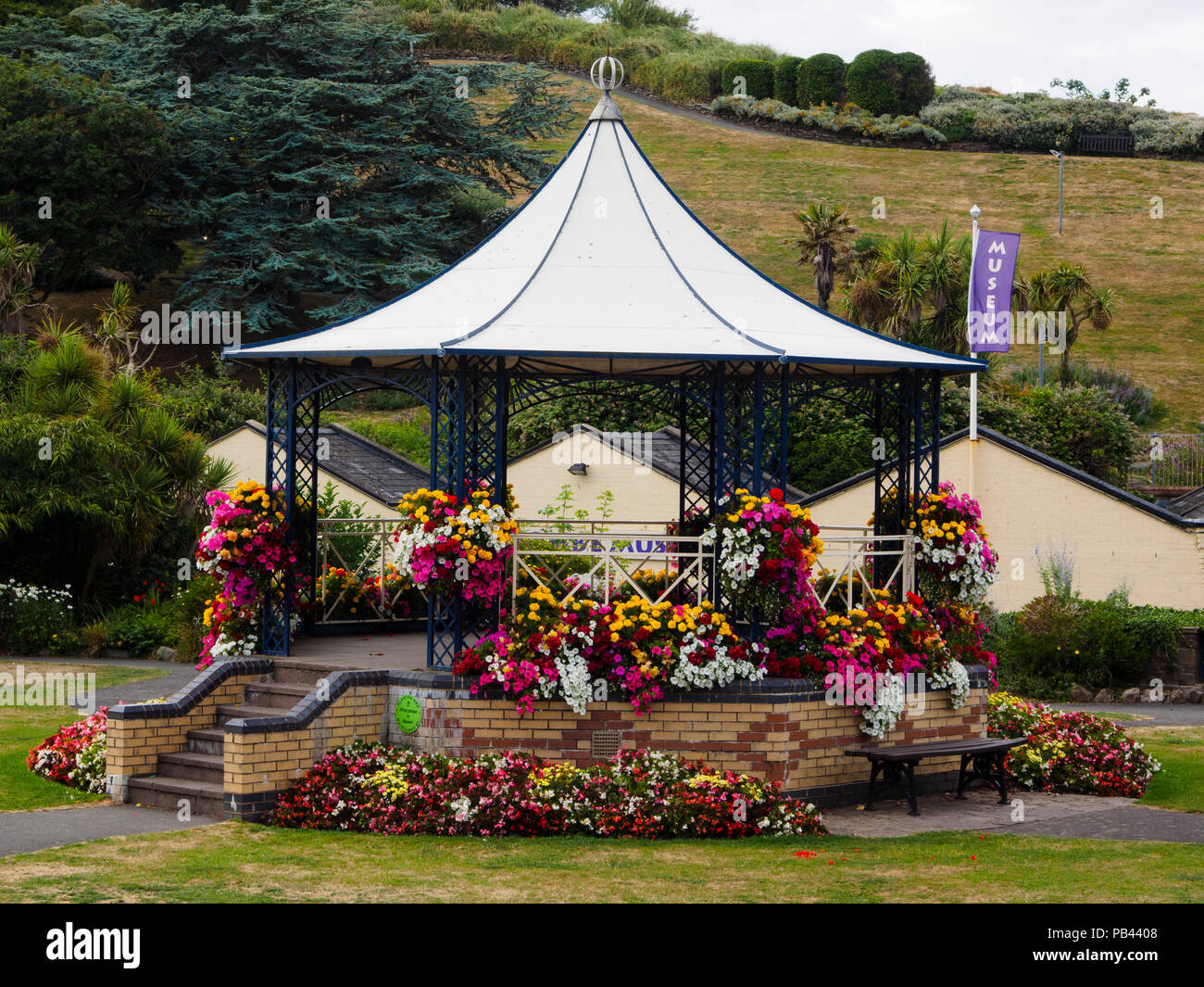 Sommer Bettwäsche Blumen bedeck der Viktorianischen Musikpavillon in Runnymede Gärten, Ilfracombe, Devon, Großbritannien Stockfoto