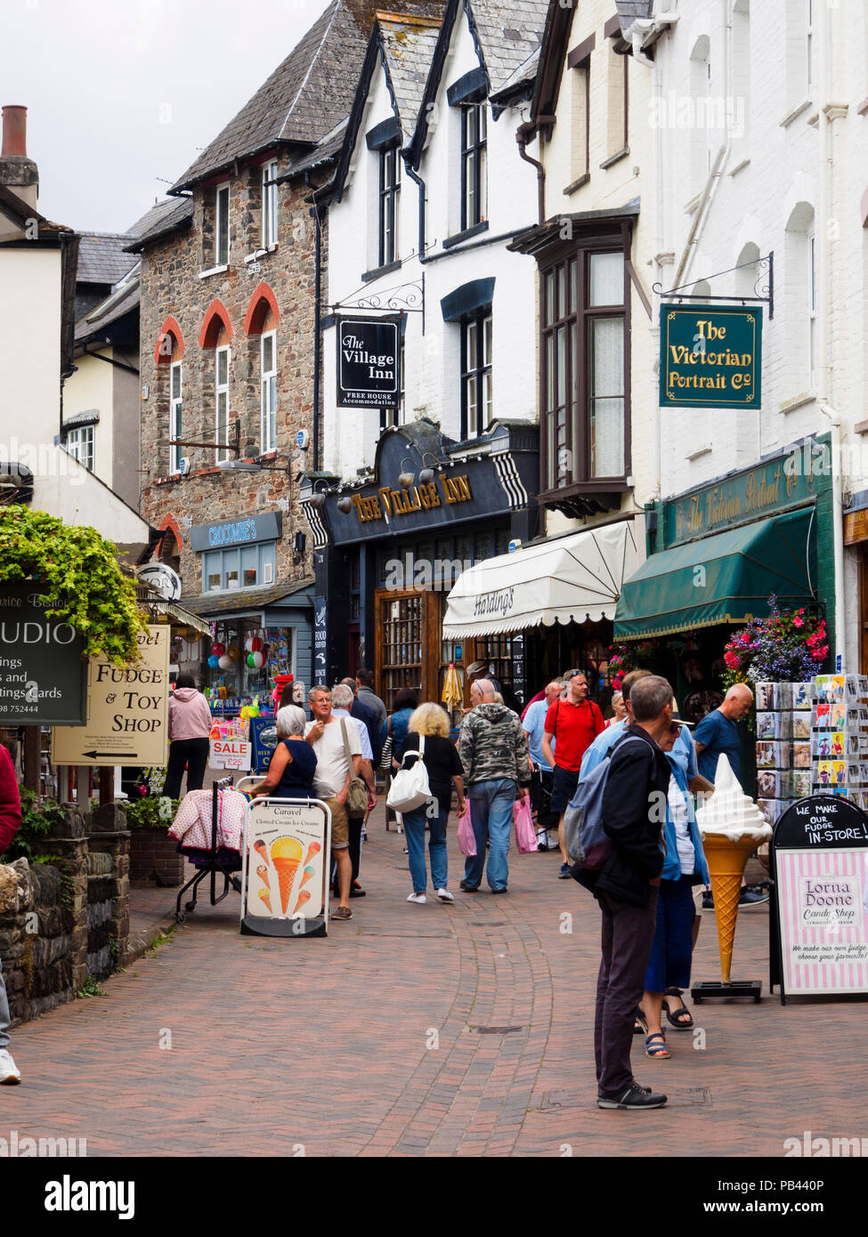 Besucher und Touristen besuchen Sie die Geschäfte in Lynmouth Street, Lynton, Devon, Großbritannien Stockfoto