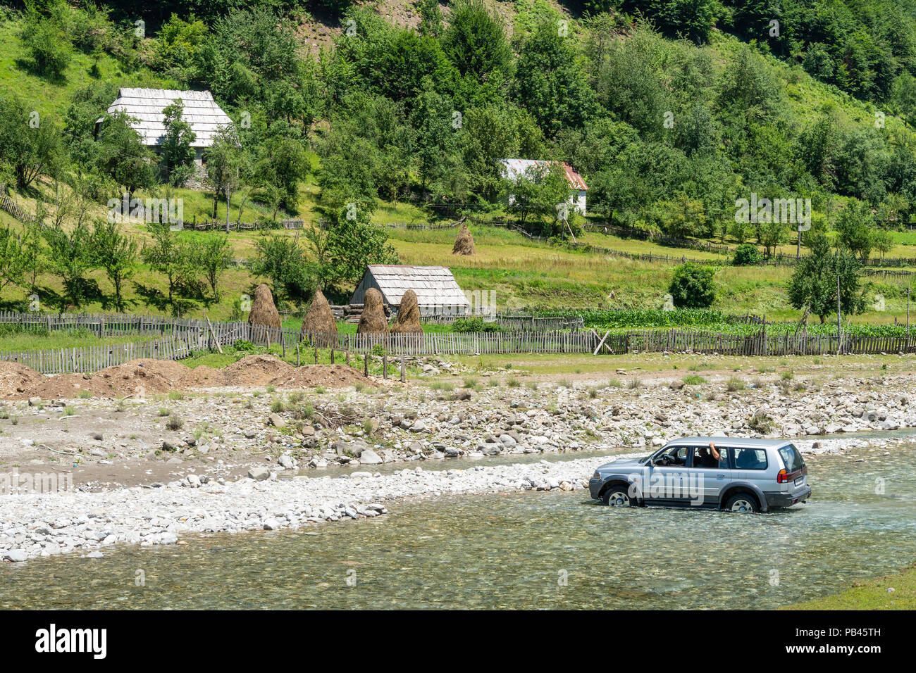 Ein Auto in der Furt des Flusses Grencars Vermosh, der nördlichste Dorf in Albanien, knapp unterhalb der Grenze mit Montinegro. Albanien. Stockfoto