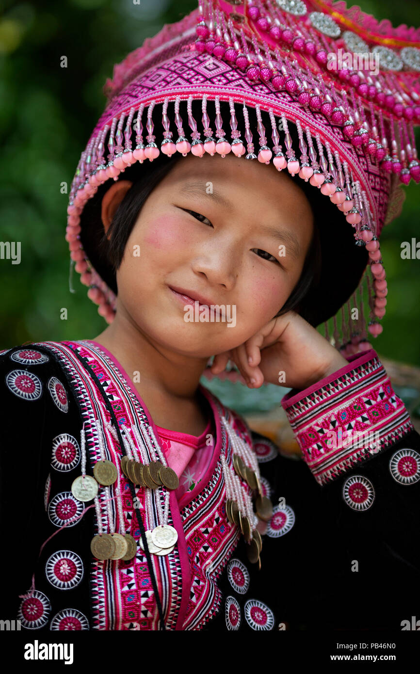 Thai Mädchen in traditioneller Kleidung und Hut, sieht mich an, in Chiang Mai, Thailand. Stockfoto