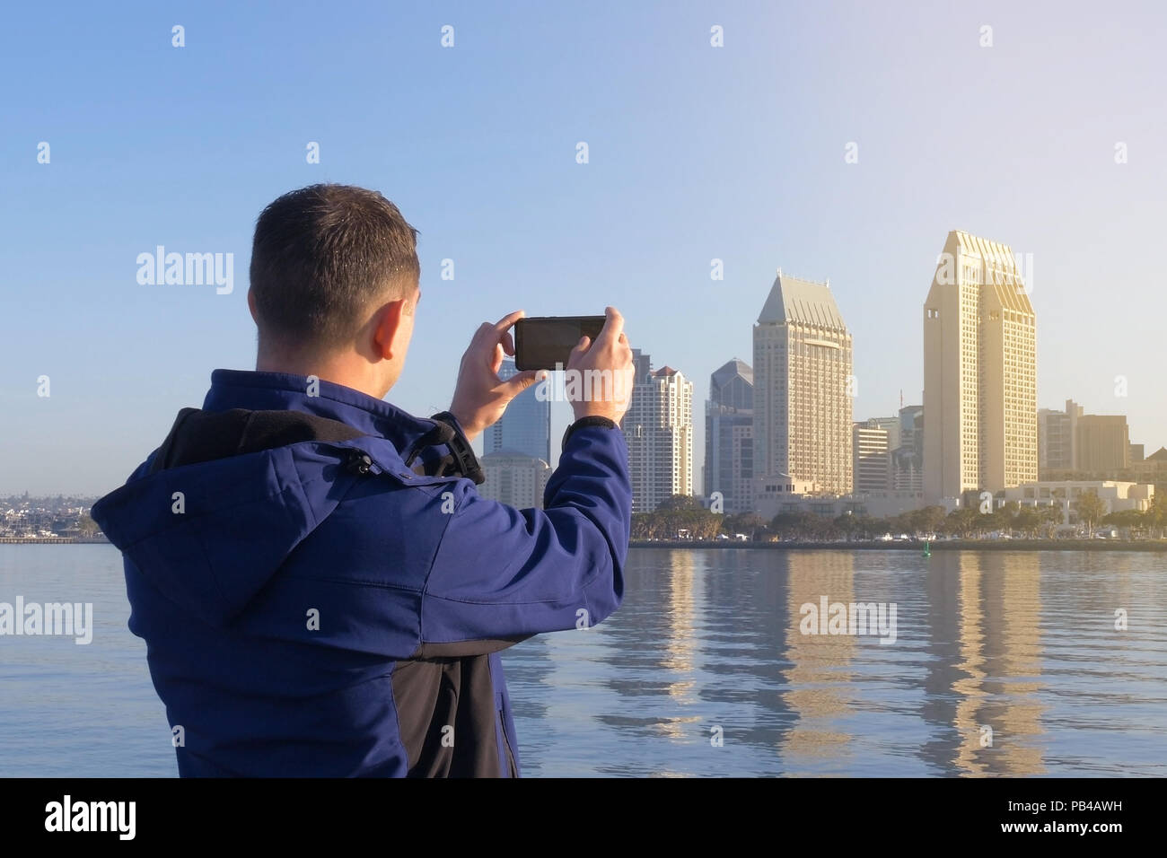 Junge männliche Tourist macht Fotos von seinen Reisen für die Platzierung in sozialen Netzwerken. Soziale Netzwerke sind eine moderne. Schaut auf das Mobiltelefon Geröll Stockfoto