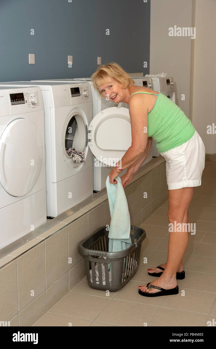 Frau mit einem trocknen Maschine in eine Waschküche. Stockfoto