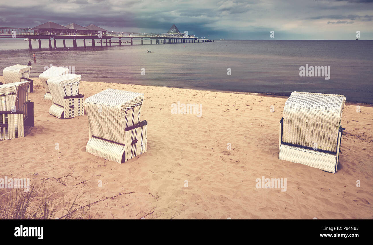 Retro stilisierte Bild eines hooded Weidenkorb Stühle am Strand, Heringsdorf, Deutschland. Stockfoto