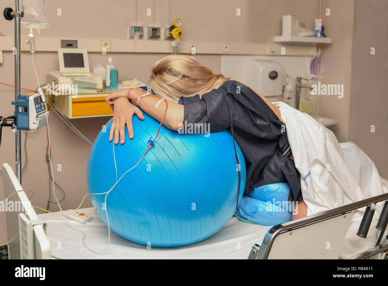 Die Frau während der Wehen auf einer Fitness Ball Geburt Krankenhaus Stockfoto
