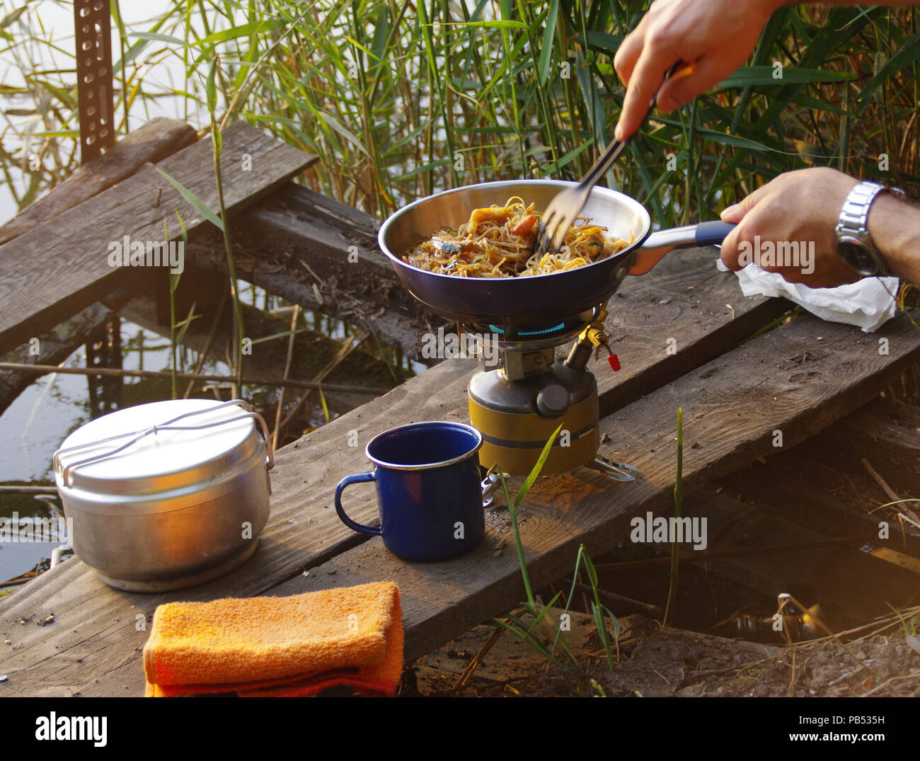 Camping Essen. Pasta auf Pan auf touristische Brand Herd. Camp Kochen am Ufer des Sees. Stockfoto