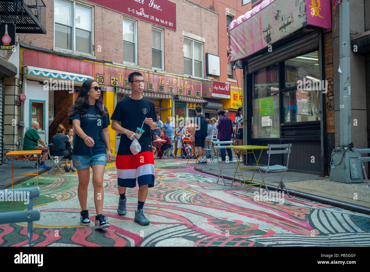 Besucher Doyers Straße in Chinatown in New York am Mittwoch, Juli 25, 2018 das Gemälde "Das Lied der Drachen und Blumen" von dem Künstler Chen Dongfan, die die 200 Meter lange Straße befindet. Das Kunstwerk ist Teil der Bemühungen der Chinatown Partnerschaft die engen, malerischen Straße in eine Fußgängerzone zu drehen. (© Richard B. Levine) Stockfoto