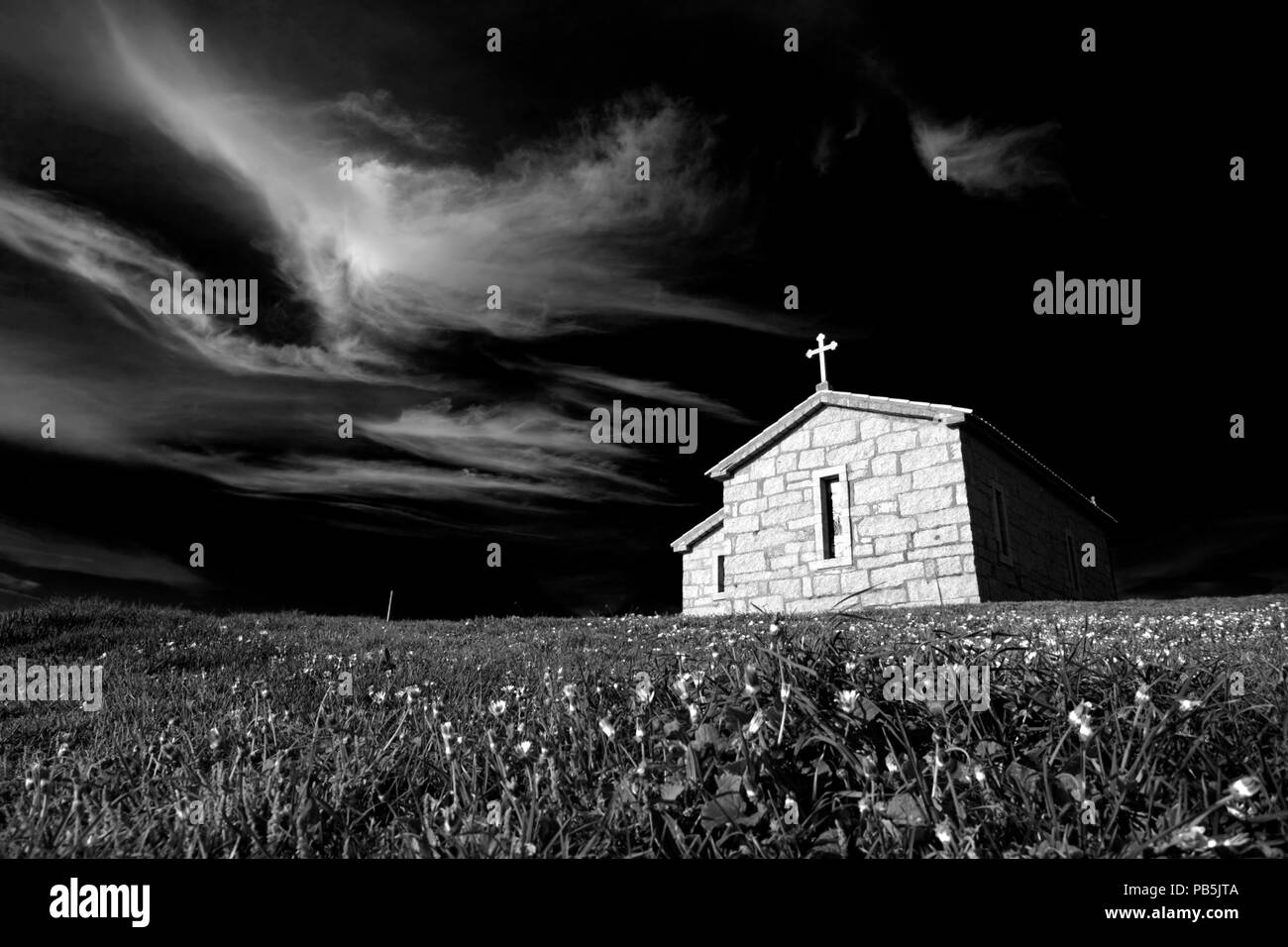 Kleine Kapelle des Heiligen Paio mit interessanten Wolken im Norden von Portugal, in der Nähe von Porto. Umgewandelt in Schwarz und Weiß. Stockfoto