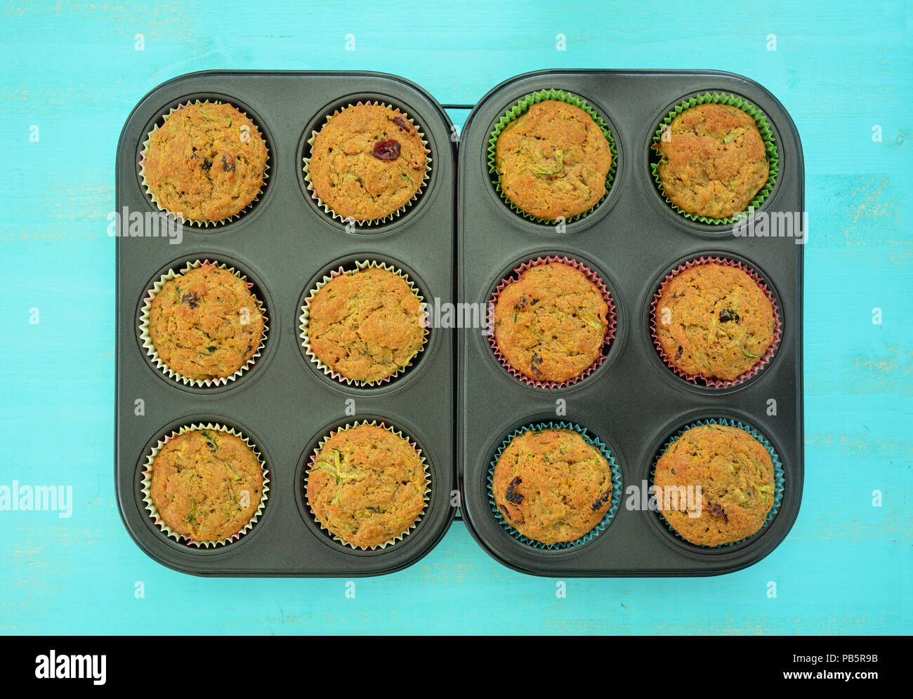 Perfekt Gebackene Zucchini cranberry Muffins in muffinzinn auf rustikalen Holzmöbeln acqua Oberfläche in Flach Format Stockfoto