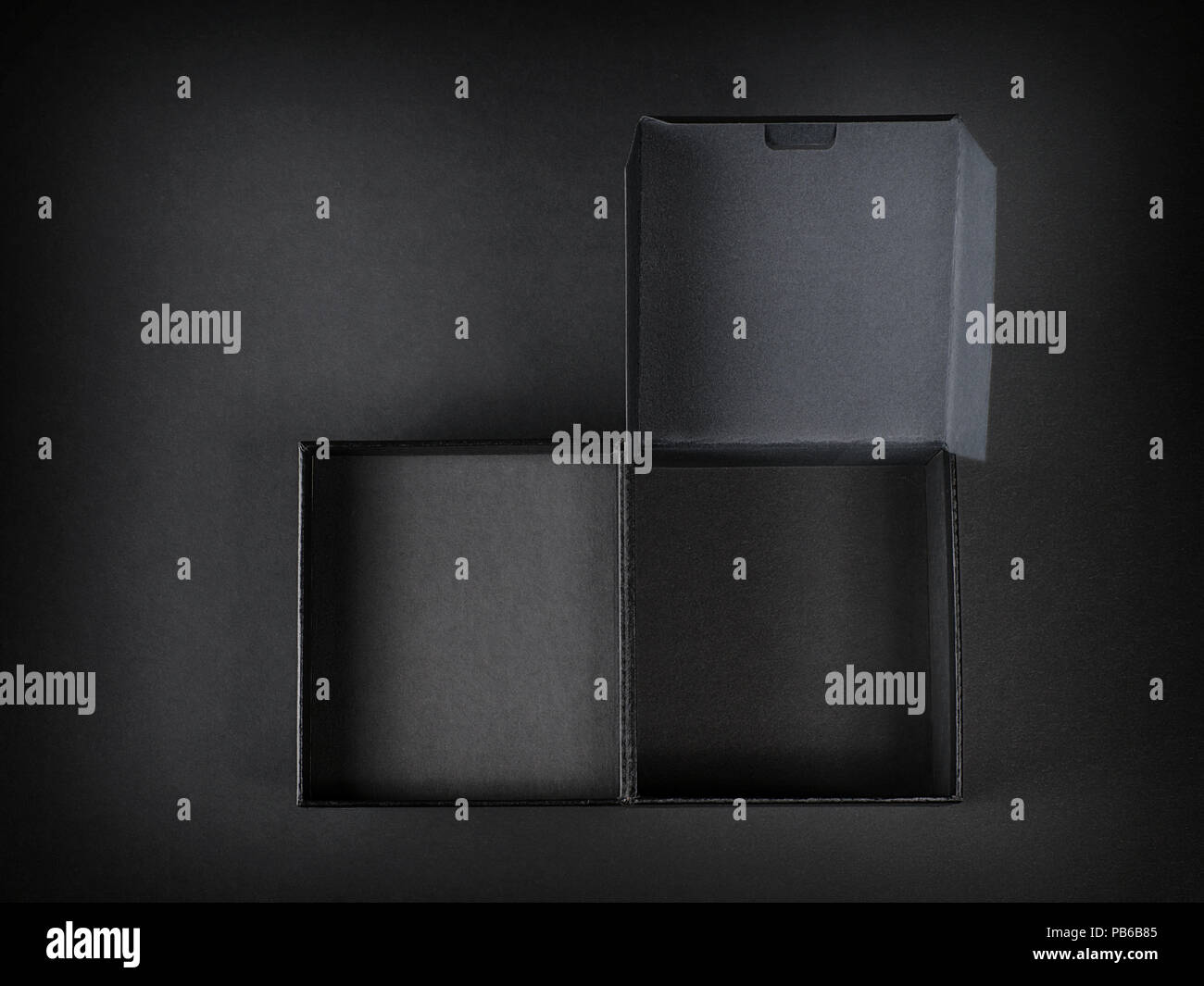 Schwarzer Karton Draufsicht auf schwarzem Hintergrund geöffnet. Low Key studio Shoot Stockfoto