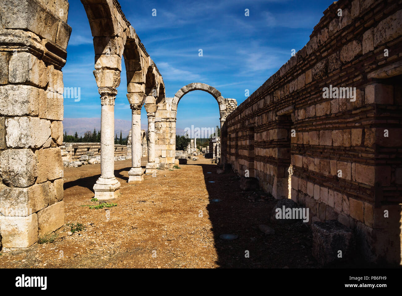 Torbogen in der Umayyaden Stadt Ruinen in Anjar mit Bergen, Bekaa-tal, Libanon Stockfoto