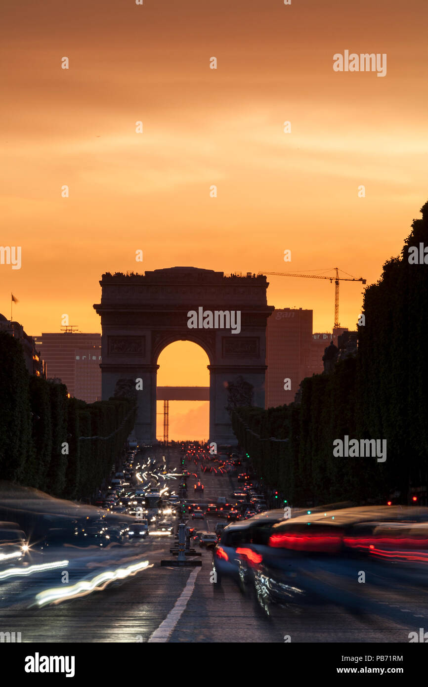 Champs Elysees und Arc de Triomphe bei Dämmerung, Paris, Frankreich mit Verkehr Wanderwege Stockfoto