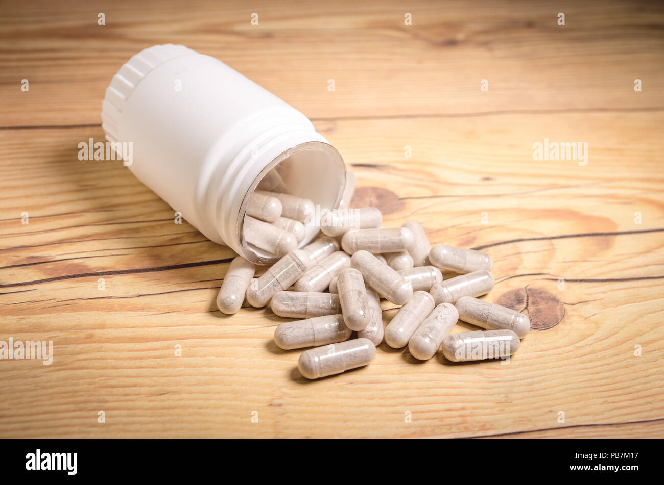 Nahrungsergänzungsmittel Kapseln auf einem Holz- Tabelle, in der die Behälter liegend Stockfoto