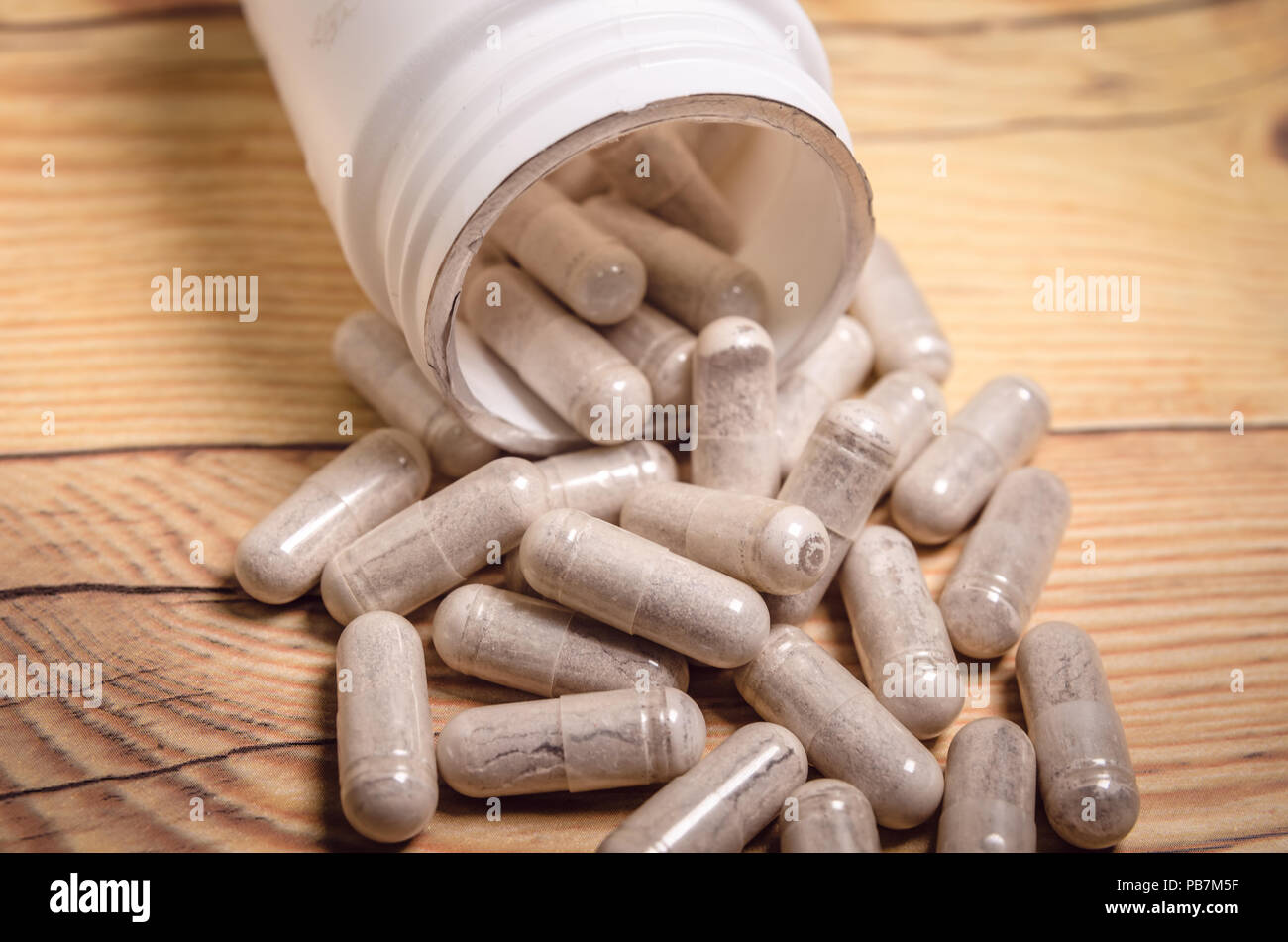 Nahrungsergänzungsmittel Kapseln auf einem Holz- Tabelle, in der die Behälter liegend Stockfoto