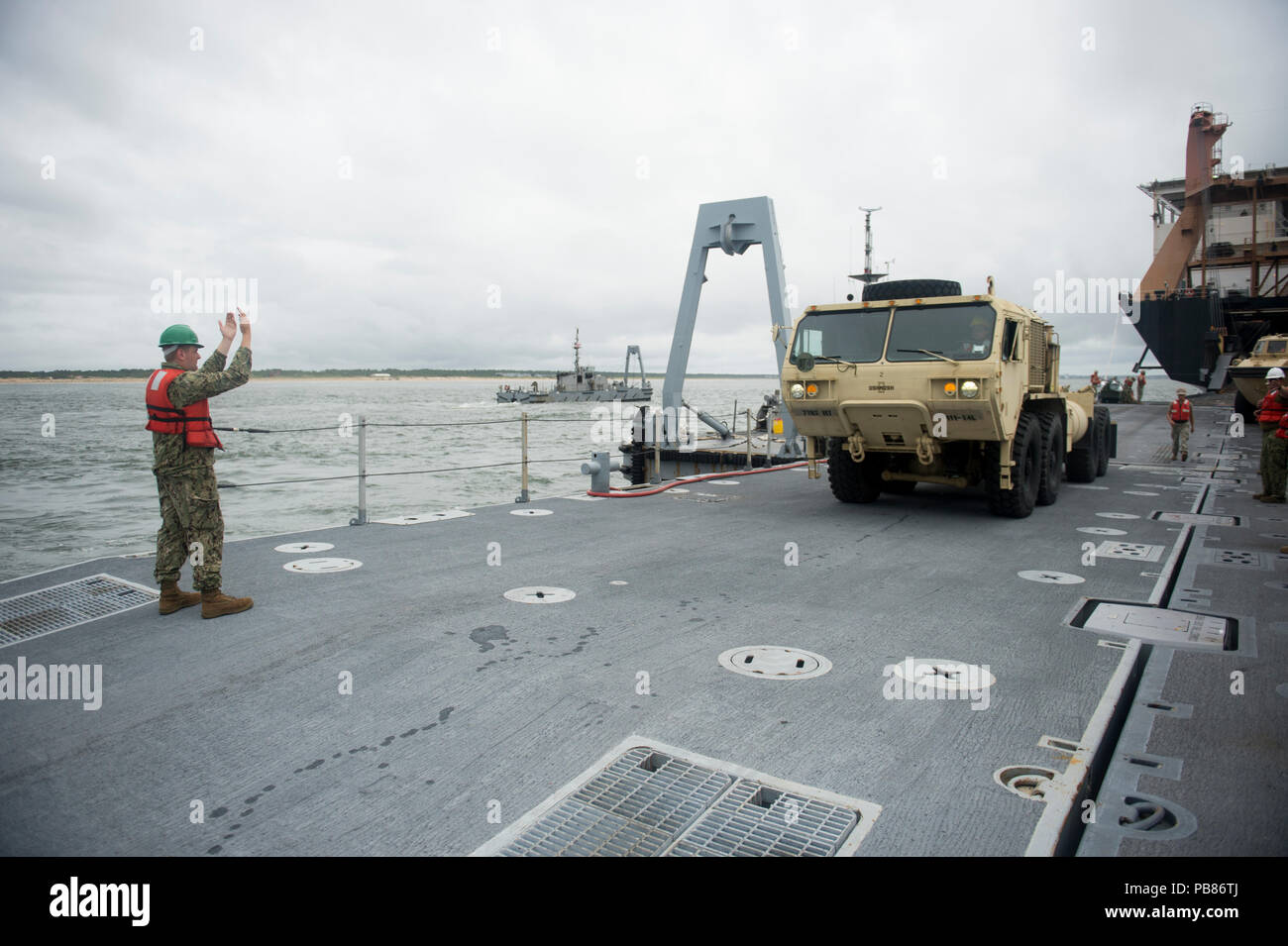 VIRGINIA BEACH, Virginia Mitglied der Roll on/Roll off-Entlastung Facility (RRDF) Team führt die US-Armee Oshkosh schwere Erweiterte Mobilität taktische Tuck (HEMTT) zu einem noch besseren Marine Leichterung System (INLS) Causeway Fähre während der Trident Sun 18 Übung. Trident Sun18 ist eine maritime Vorpositionierung Kraft (MPF) beabsichtigt die Ausbildung zu Personal in Bezug auf die im Stream Offload für militärische Fahrzeuge und Geräte zur Verfügung zu stellen. (U.S. Marine Foto von Mass Communication Specialist 2. Klasse Kenneth Gardner) Stockfoto