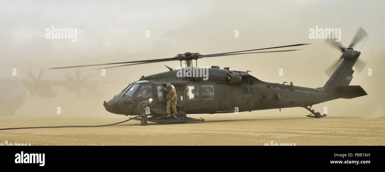 Ein Marine bereitet eine Armee UH-60 Black Hawk von einem USMC C-130 Hercules auf der Firebird Angriff Landeplatz im Yukon Training Area, wo Soldaten aus E Unternehmen, 1 Battalion, 52nd Aviation einen vorderen Bereich Tanken Punkt Juli 19 tanken. (Armee Foto/John pennell) Stockfoto