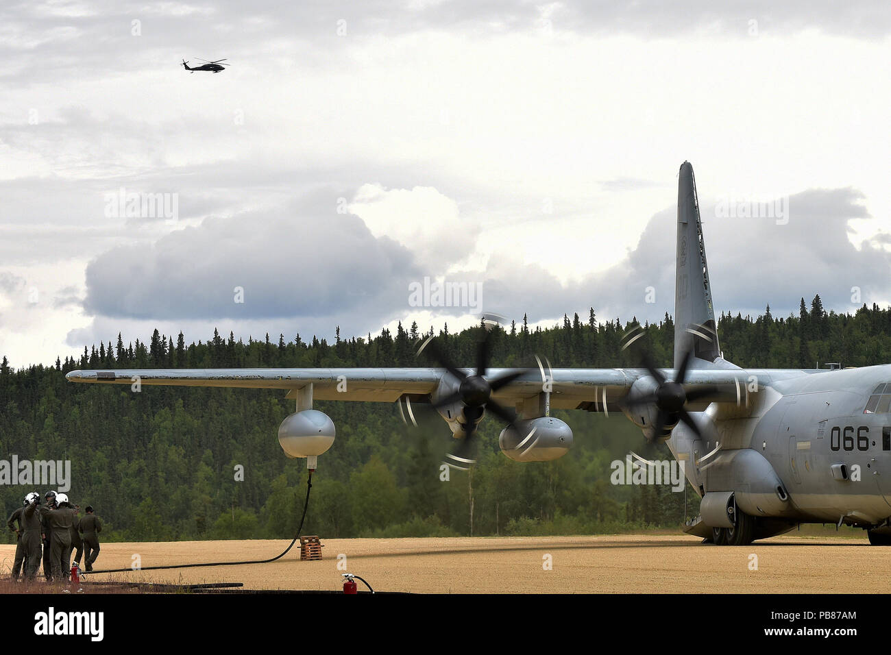 Marines bereiten Sie eine Armee UH-60 Black Hawk von einem USMC C-130 Hercules auf der Firebird Angriff Landeplatz im Yukon Training Area, wo Soldaten aus E Unternehmen, 1 Battalion, 52nd Aviation einen vorderen Bereich Tanken Punkt Juli 19 tanken. (Armee Foto/John pennell) Stockfoto