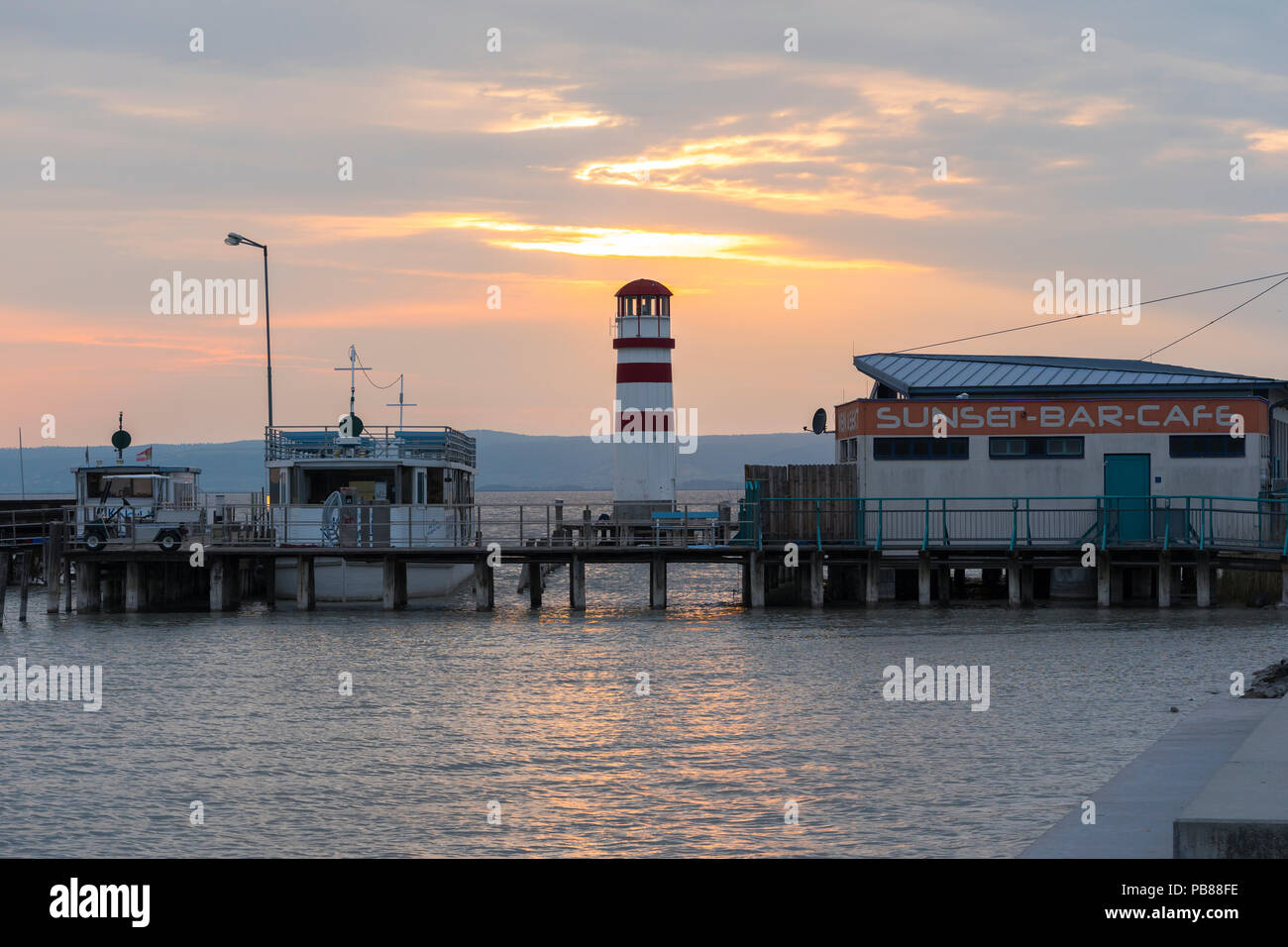 Der Leuchtturm (Leuchtturm Podersdorf Podersdorf) und Sunset-Bar bei Sonnenuntergang im Sommer am Ufer des Neusiedler See, Burgenland, Österreich Stockfoto