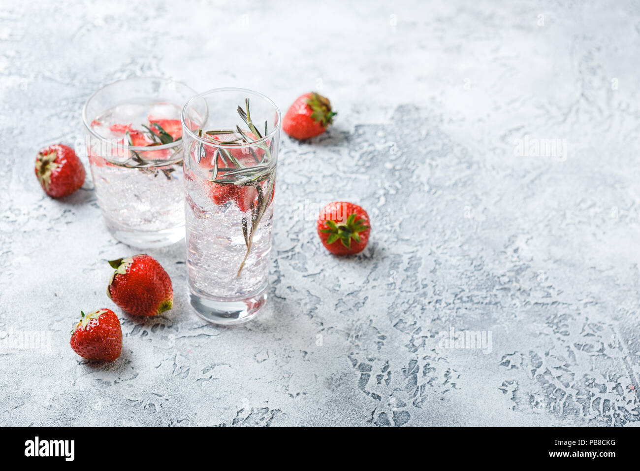 Alkoholische oder alkoholfreie Cocktails mit Erdbeeren und Rosmarin und Eis im Glas Gläser. Freier Platz für Text. Stockfoto