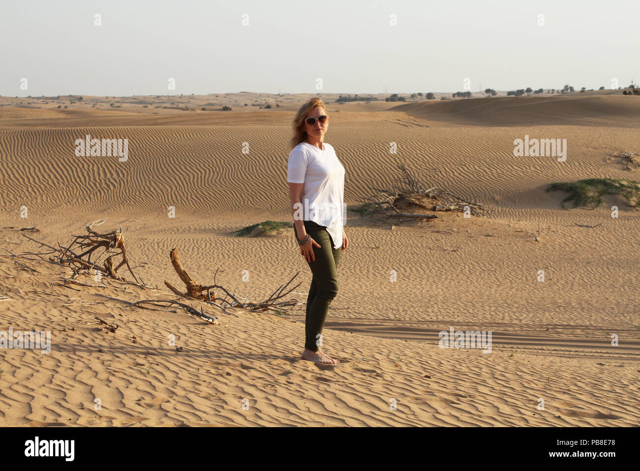 Eine Frau, die barfuß im Sand in der Wüste, eine halbe Umdrehung drehen. Stockfoto