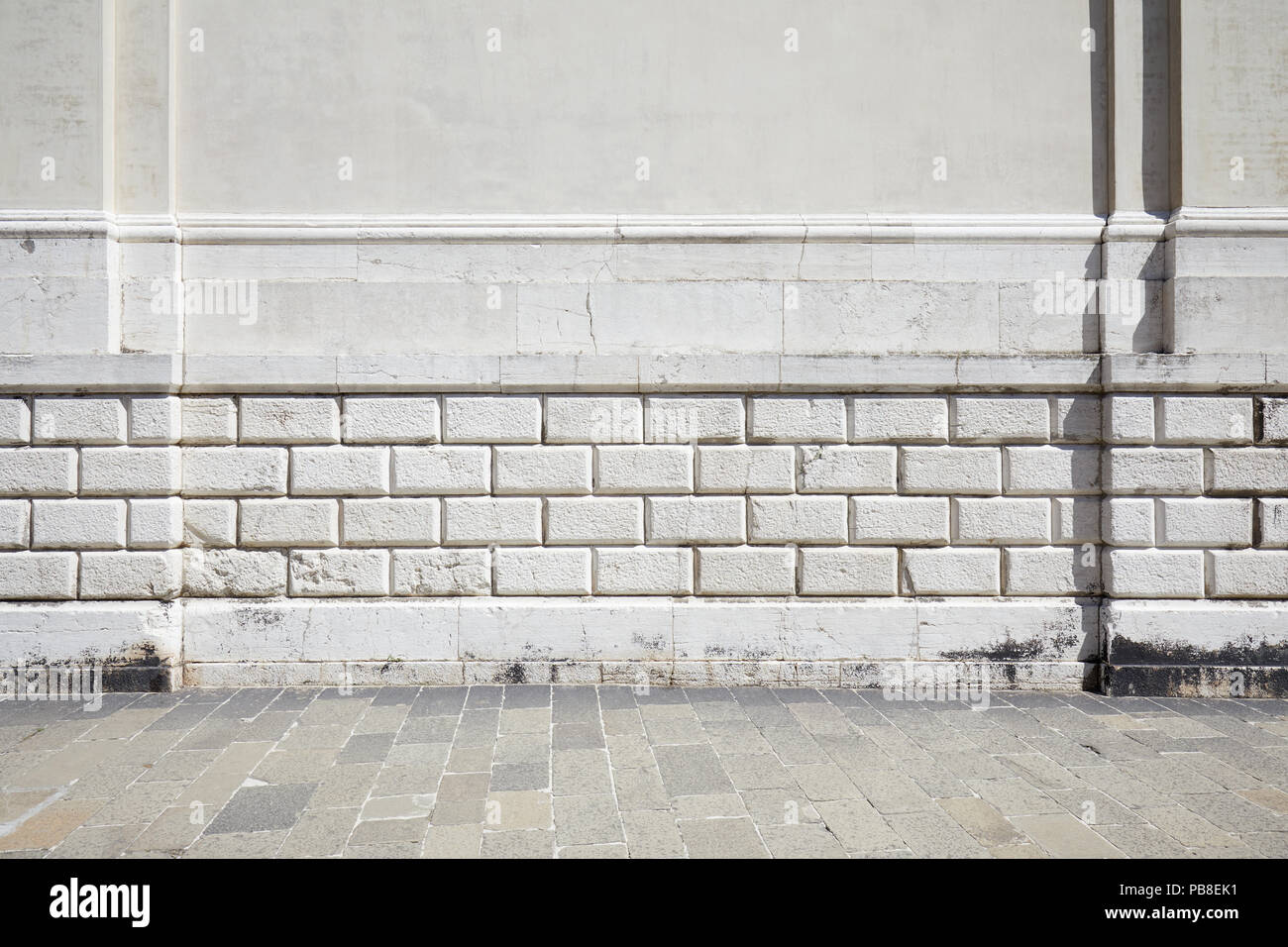 Leere Fliesen- stein Bürgersteig und weiße Wand mit Spritzguss Stockfoto