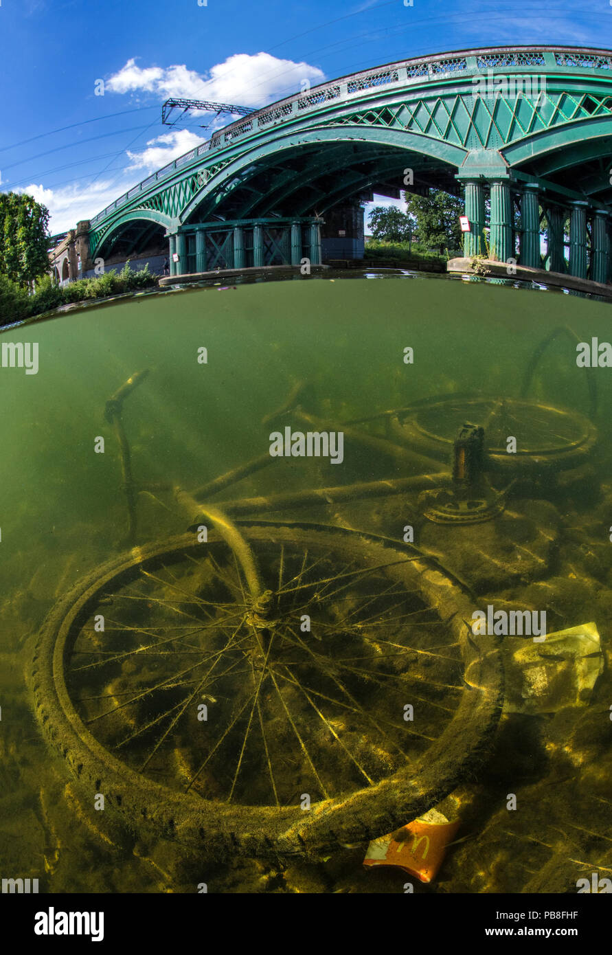 Verworfen Fahrrad im Fluss Nene, Peterborough, Cambridgeshire, England. UK August. Die Brücke wurde von William Cubitt im Jahr 1850 und ist die einzige gusseiserne Brücke noch auf einer großen Schnellzug Linie. Stockfoto