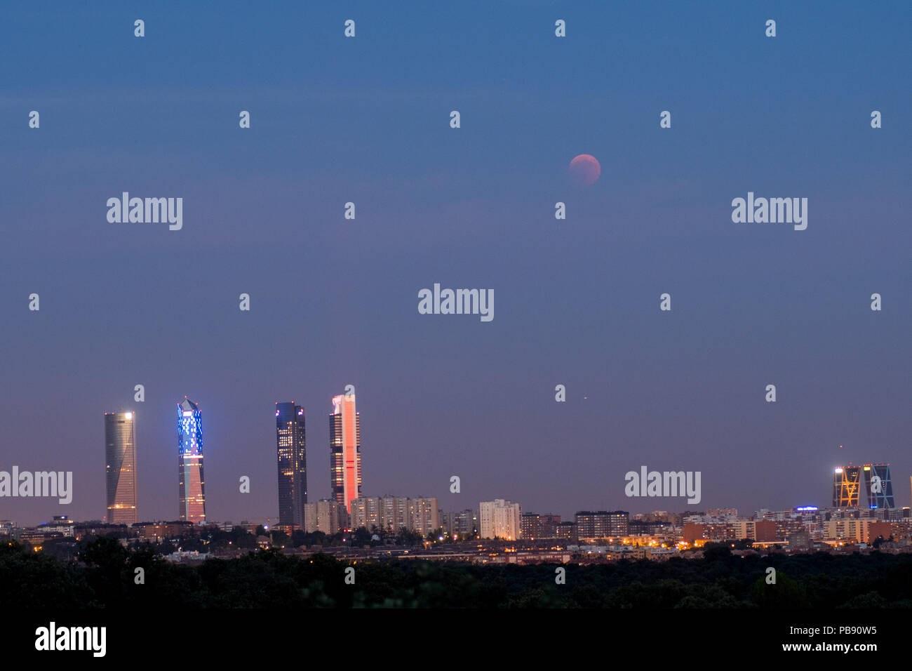 Madrid, Spanien. 27. Juli, 2018. Der Mond scheint in der Nähe der vier Türme Wolkenkratzer bei einer totalen Mondfinsternis, die längste Sonnenfinsternis des Jahrhunderts, mit einer Dauer von 1 Stunde 43 Minuten und 35 Sekunden. In Madrid, Spanien. Credit: Marcos del Mazo/Alamy leben Nachrichten Stockfoto