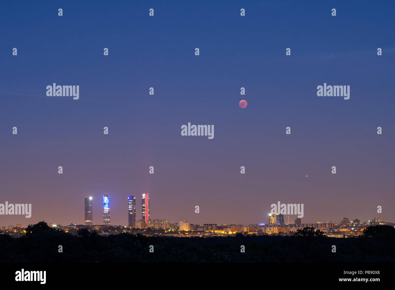 Madrid, Spanien. 27. Juli, 2018. Der Mond scheint in der Nähe der vier Türme Wolkenkratzer bei einer totalen Mondfinsternis, die längste Sonnenfinsternis des Jahrhunderts, mit einer Dauer von 1 Stunde 43 Minuten und 35 Sekunden. In Madrid, Spanien. Credit: Marcos del Mazo/Alamy leben Nachrichten Stockfoto