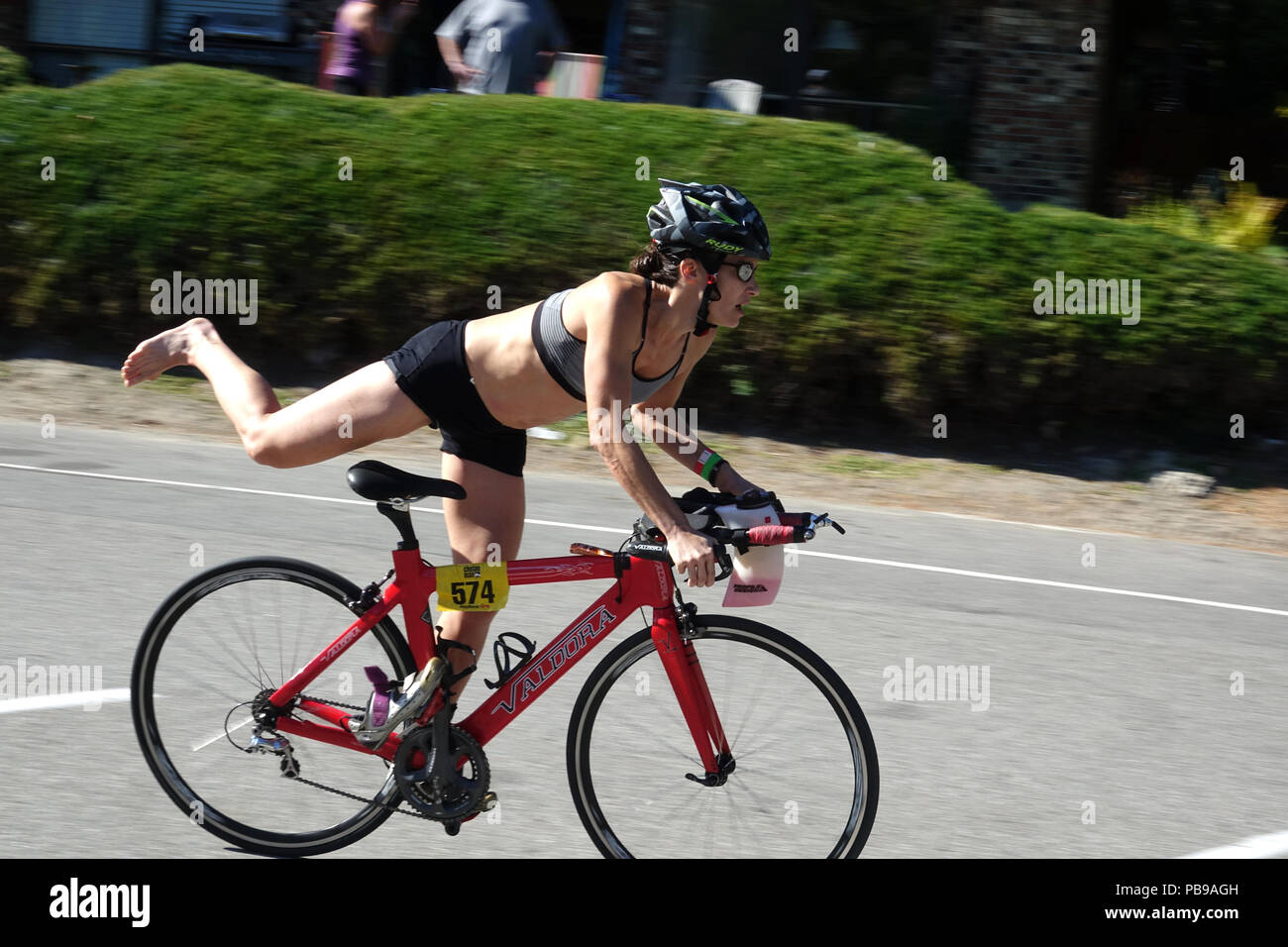 Eine Triathletin demontiert am Ende Ihres bike Session in der Chelanman Multisport Wochenende in Chelan Washington Stockfoto