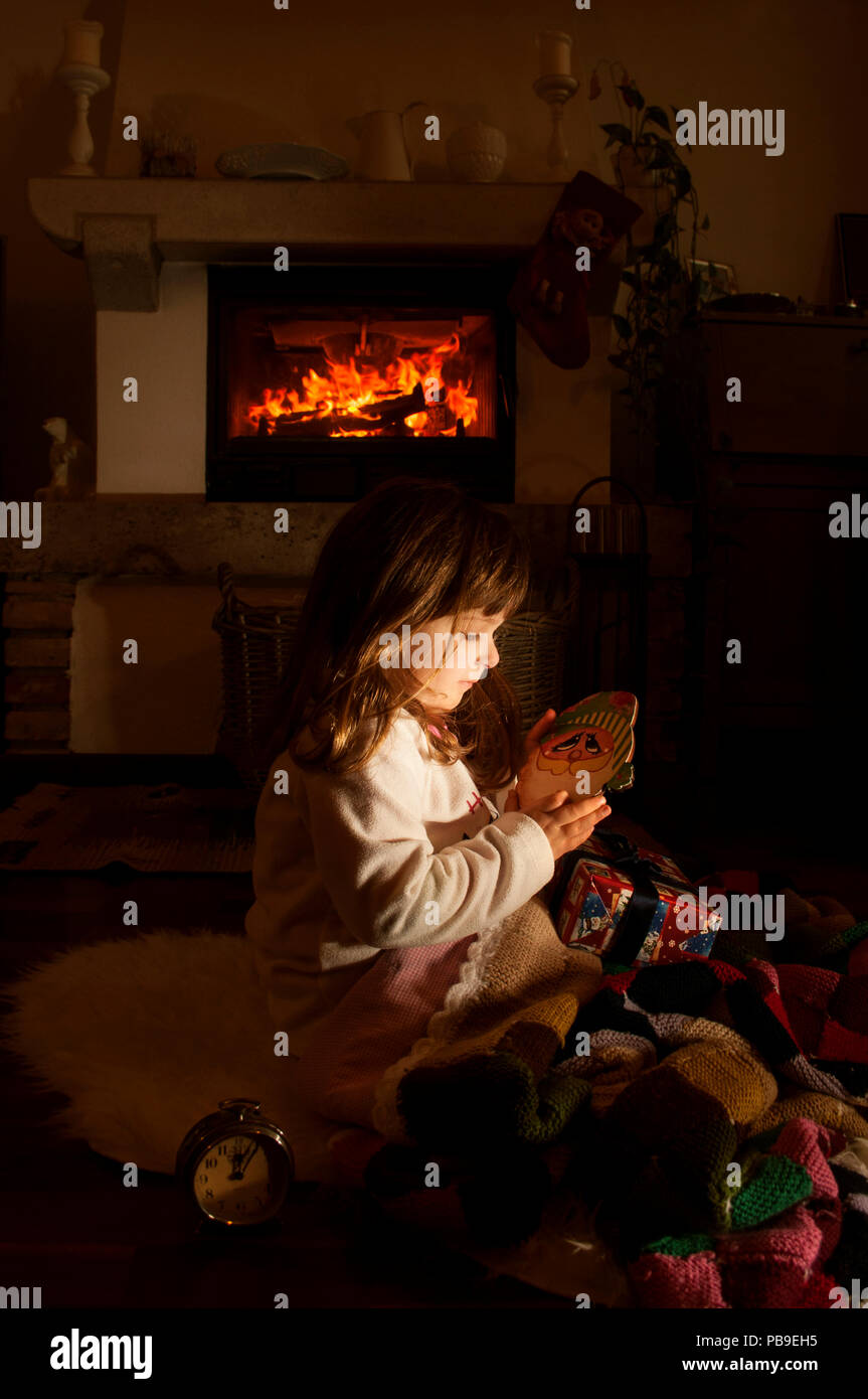 Kleines Mädchen mit Weihnachtsgeschenk in der Nacht dunkle Zimmer Stockfoto