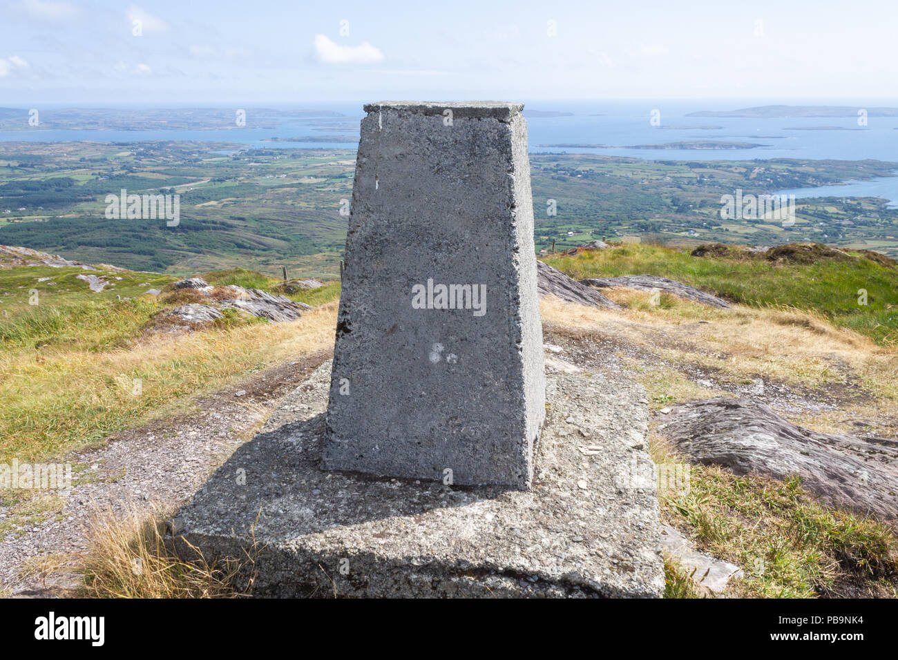 Triangulation Punkt auf dem Gipfel des Mount Gabriel, West Cork, Irland, mit Blick auf die Roaring Water Bay darüber hinaus. Stockfoto