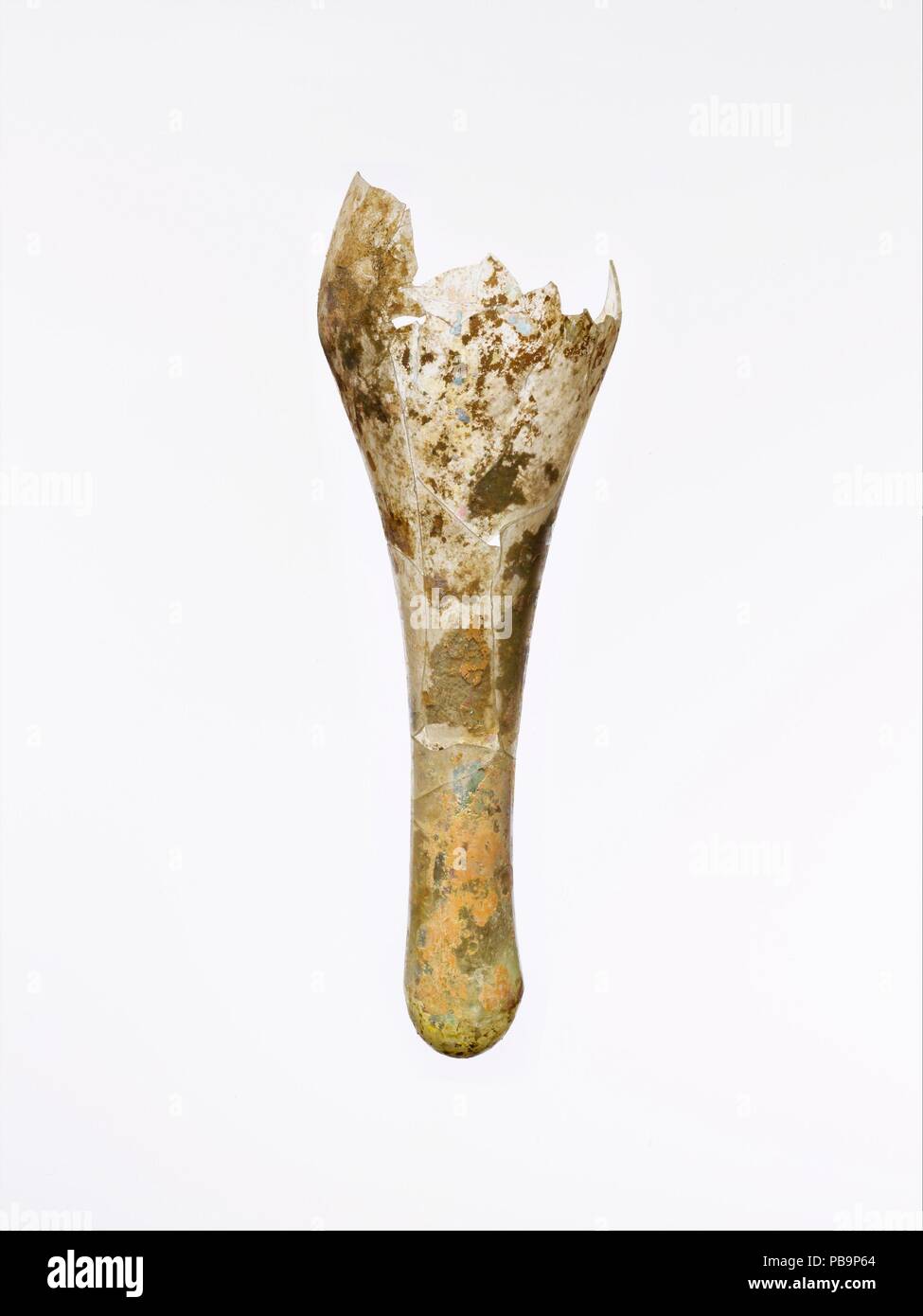 Glas Flasche fusiform Fragment. Kultur: Roman. Abmessungen: Andere: 2 3/4 in. (7 cm) Länge: 8 3/8 in. (21,3 cm). Datum: 3.-4. Jh. N.CHR.. Farblos mit blass grünlich-gelben Farbton. Fusiform Leib, und dann etwas zu dicken, runden Boden krümmen. Gebrochen und repariert Fragment, fehlt in der oberen Hälfte des Körpers und der Rim; wenige Blasen; Mattierung und viele Patches der tiefen, irisierende Verwitterung. Verkrusteten Böden im Innenbereich. Museum: Metropolitan Museum of Art, New York, USA. Stockfoto