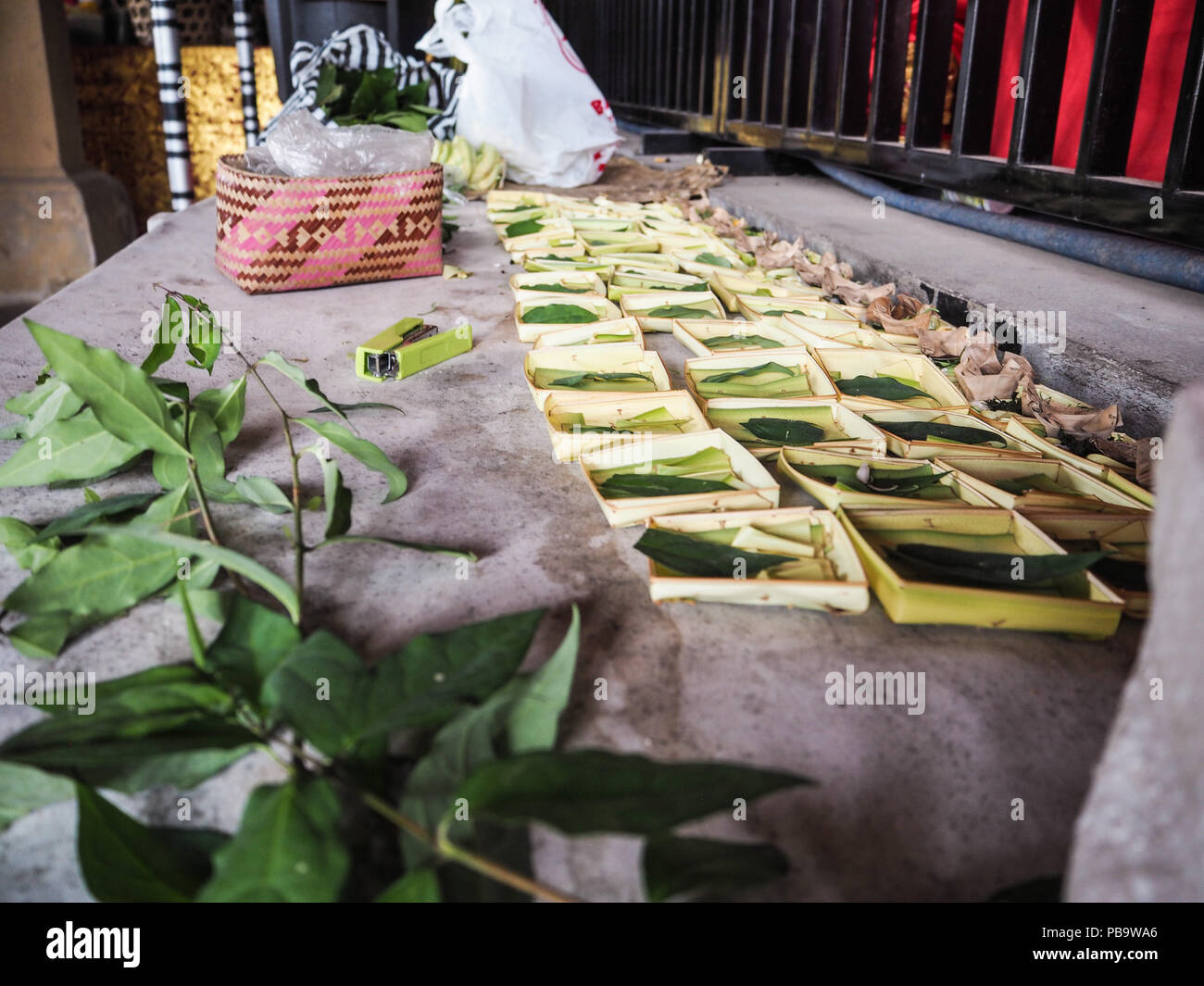 Reihen von Palm Körbe für canang Sari verwendet verlassen und mit Blütenblättern und Reis gefüllt, Bali. Stockfoto Reihen von Palm Körbe für canang Sari verwendet verlassen und mit Blütenblättern und Reis gefüllt, Bali. Stockfoto