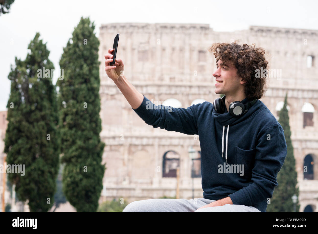 Hübscher junger Mann im Sport Tücher unter selfie mit seinem Smart Phone in Rom mit dem Kolosseum im Hintergrund Stockfoto