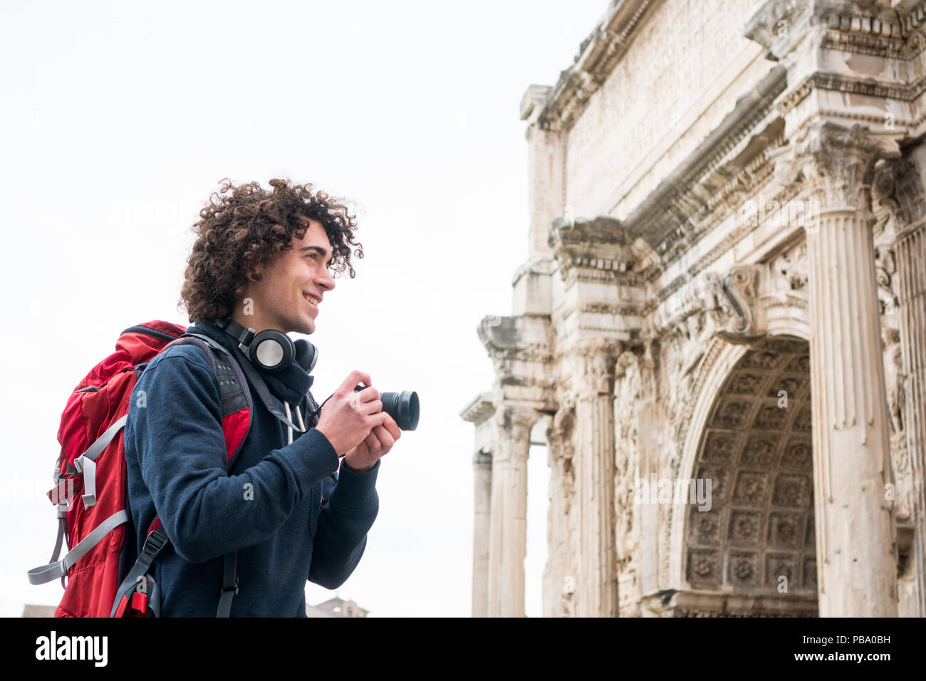 Hübscher junger Tourist, Fotos von Forum Romanum in Rom, Italien. Backpacker mit seiner Kamera Stockfoto