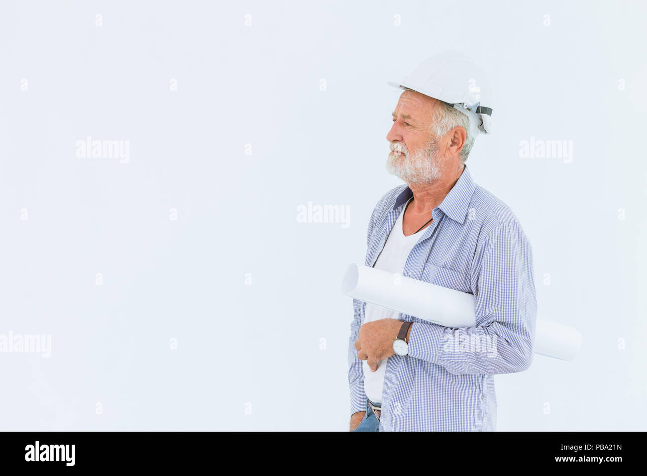 Senior schweren Bau Ingenieur mit harten Hut mit Papierrolle blueprint im Studio mit weißen Raum für Text Stockfoto