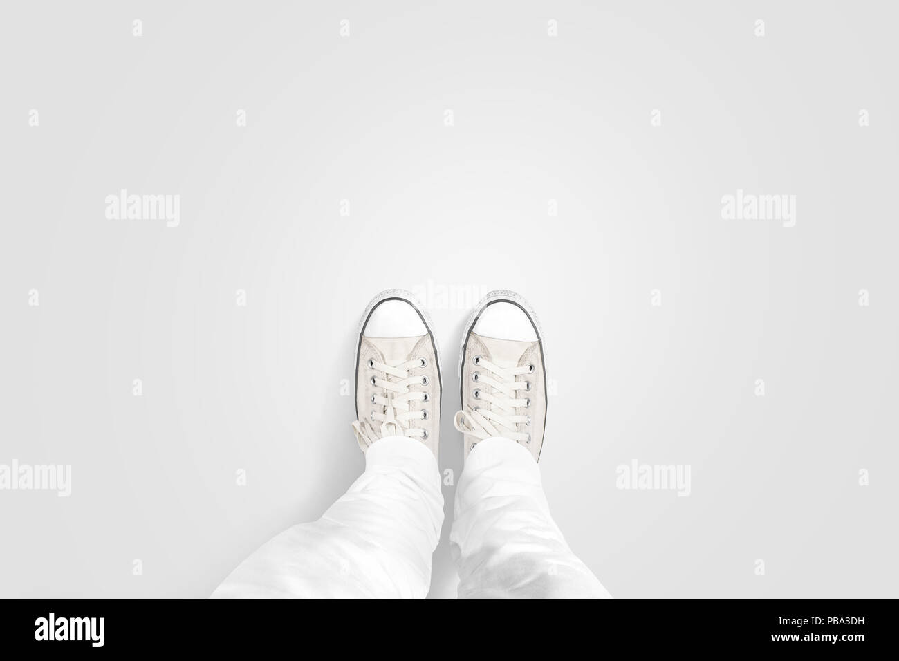 Person, die Foto von seinen Füßen stehen auf blank, isoliert, Ansicht von oben, clipping path. Boden design Mock up. Mann tragen Gumshoes und gerade nach unten. Stockfoto