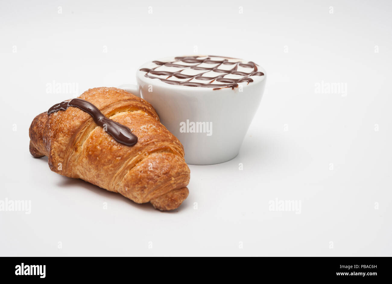 Wunderschönes Frühstück mit Cappuccino und Brioche im Hintergrund Stockfoto