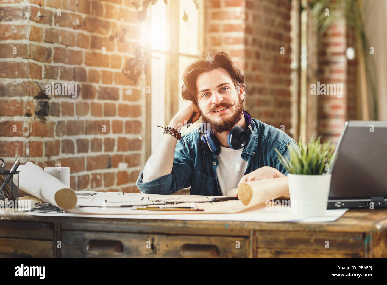 Hübscher junger bärtiger Mann Architekt lächelte Fröhlich saß an seinem Schreibtisch im Büro copyspace, Zeichnung, Konstruktion, Engineering, architektonische Kreativität beruflichen Erfolg Arbeitnehmer Unternehmer Stockfoto