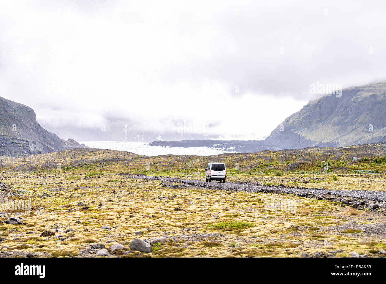 Blick auf den Nationalpark Skaftafell, Island Gletscherzungen mit Tour Van auf Feldweg, Steine, Moos, Nebel, Wolken, Felsen, Berge Stockfoto