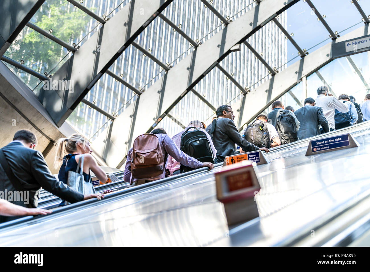London, UK, 26. Juni 2018: Geschäftsleute, Kaufleute, Frauen, Männer, Rolltreppe, in U-Rohr der Canary Wharf U-Bahn morgens auf dem Weg zur Arbeit stand Stockfoto