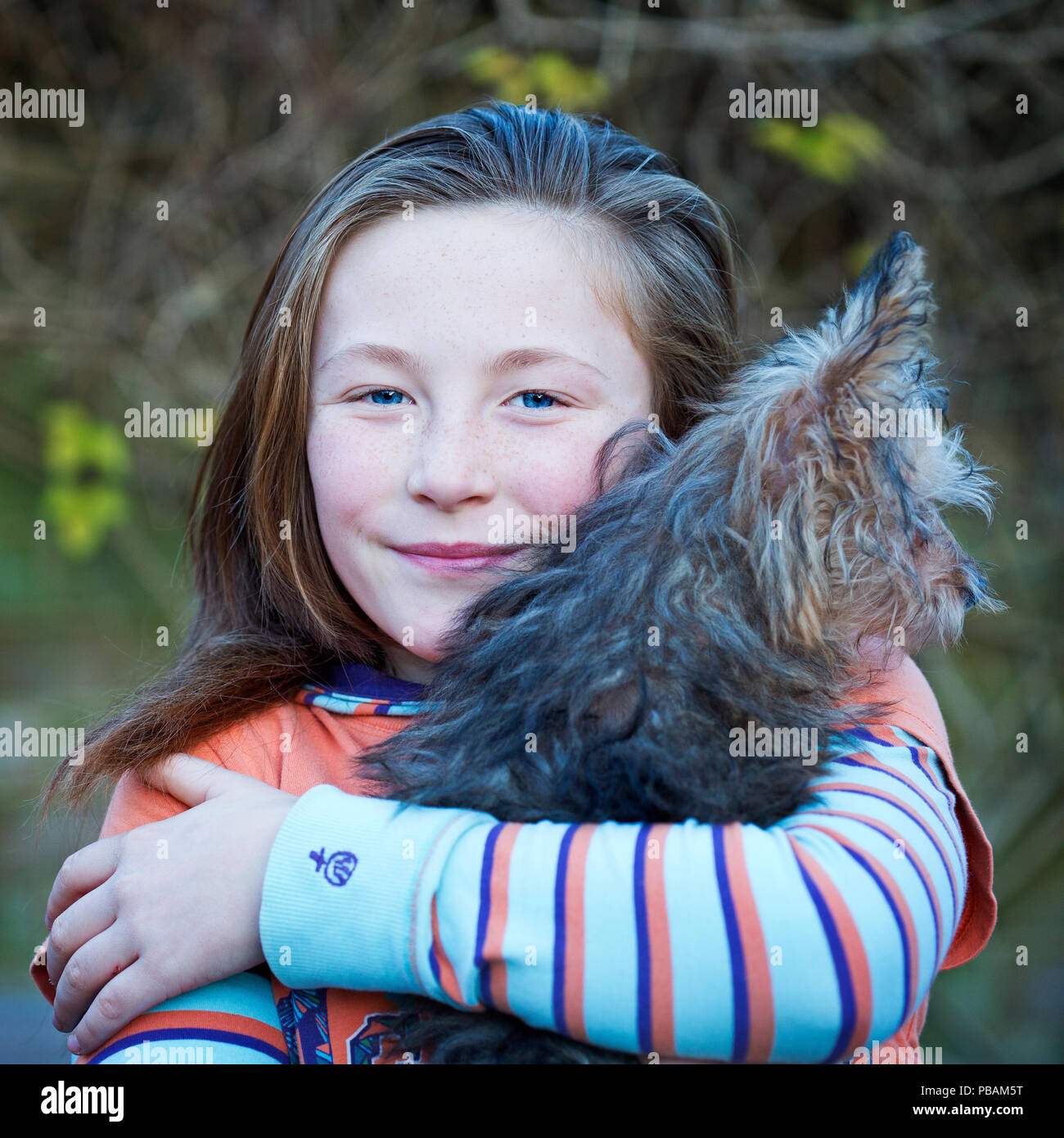 Ein junges Mädchen von 10 bis 12 Jahren einen kleinen Hund Stockfoto