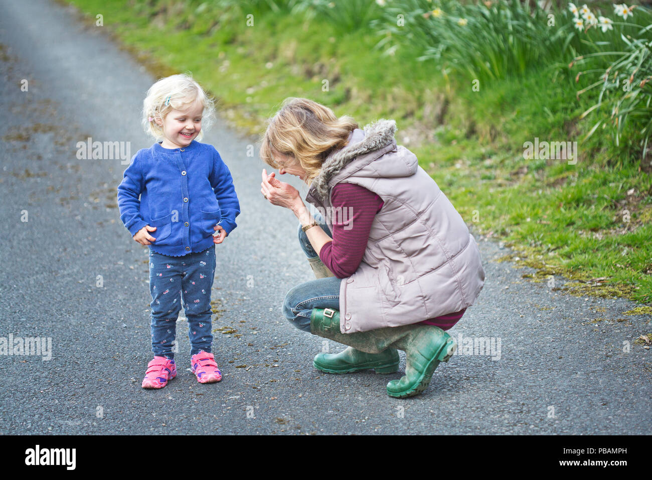 Ein 2 Jahre altes Mädchen im Freien mit ihrer Großmutter Stockfoto