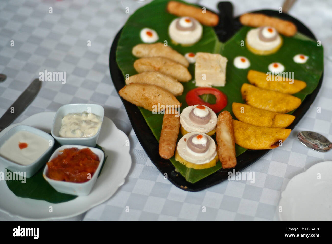 Die Probenahme von kolumbianischen Delikatessen, einschließlich carimañolas de jaiba, empanaditas de Carne, deditos de Queso, bollo de mazorca, butifarra, queso Kosten Stockfoto