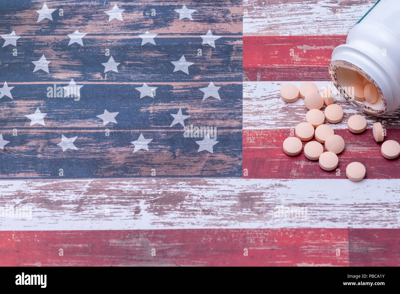 Flasche Pillen spill auf Amerikanische Flagge mit Raum für Text Stockfoto