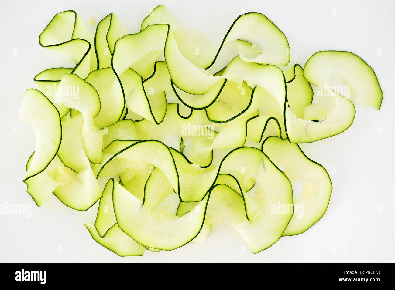 Zucchini Bänder mit spiralizer auf weißem Hintergrund in Flach Zusammensetzung Stockfoto